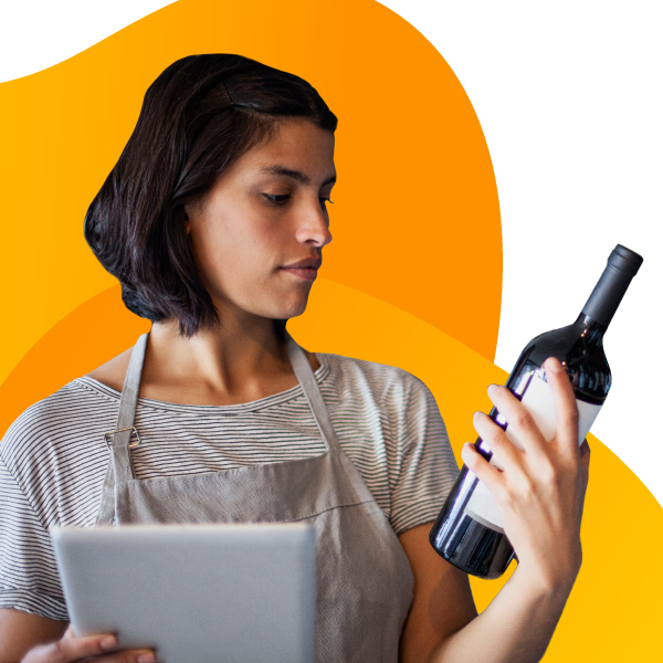 A business owner inspects a bottle of wine.