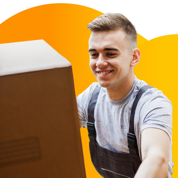 A moving company employee carries a box of household goods.