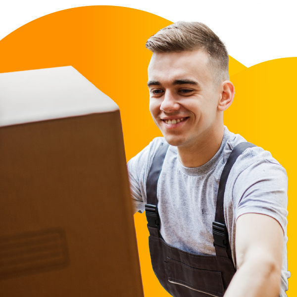 A moving company employee carries a box of household goods.