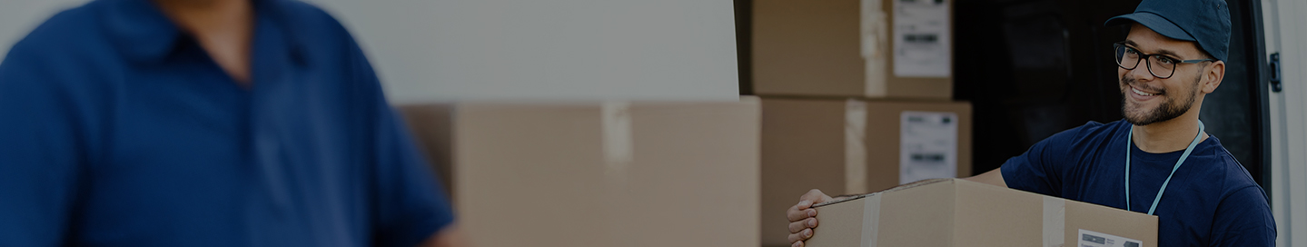 An employee at a moving company transports boxes of household goods. An employee at a moving company transports boxes of household goods.