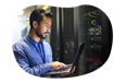 Employee of a small tech business reviewing readings of a computer mainframe.