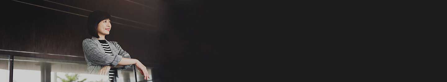 Person looking over a balcony into the distance.