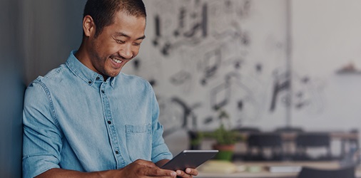 Person smiling and looking down at their tablet.