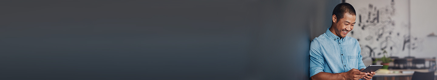 Person smiling and looking down at their tablet.