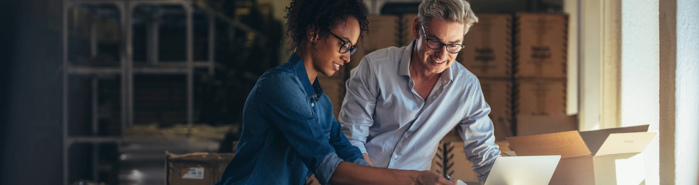 Two small business owners exploring business insurance options on their office computer.